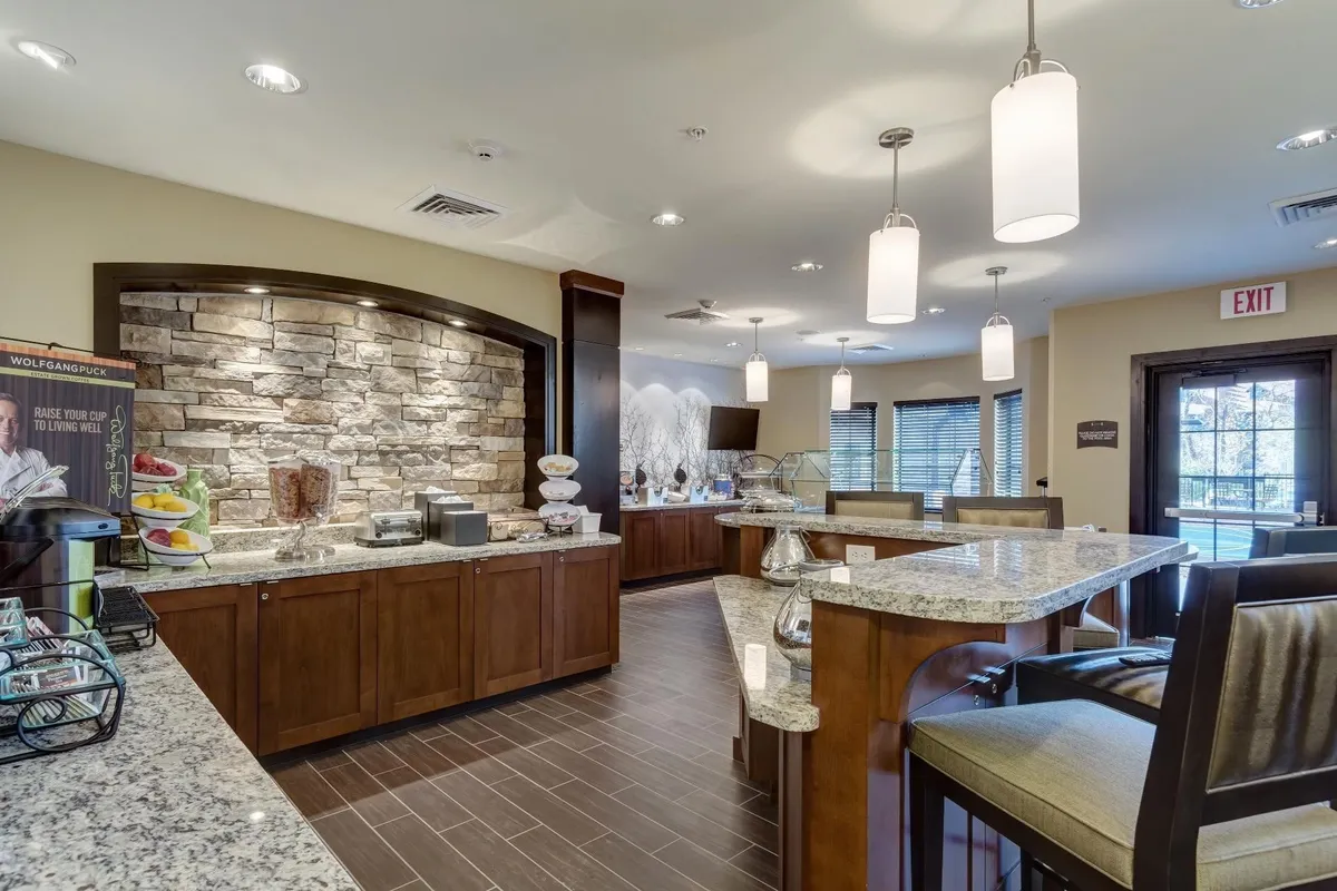 A cozy breakfast buffet area with a granite countertop and a stone wall backdrop, illustrating a space where meals can be enjoyed and prepared. The mood is inviting and the setup supports both solitary and communal dining, with the countertop suitable for meal prep or informal gatherings.